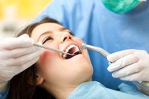 dentist using dental tools to treat patient in chair, Guelph, ON best dentist